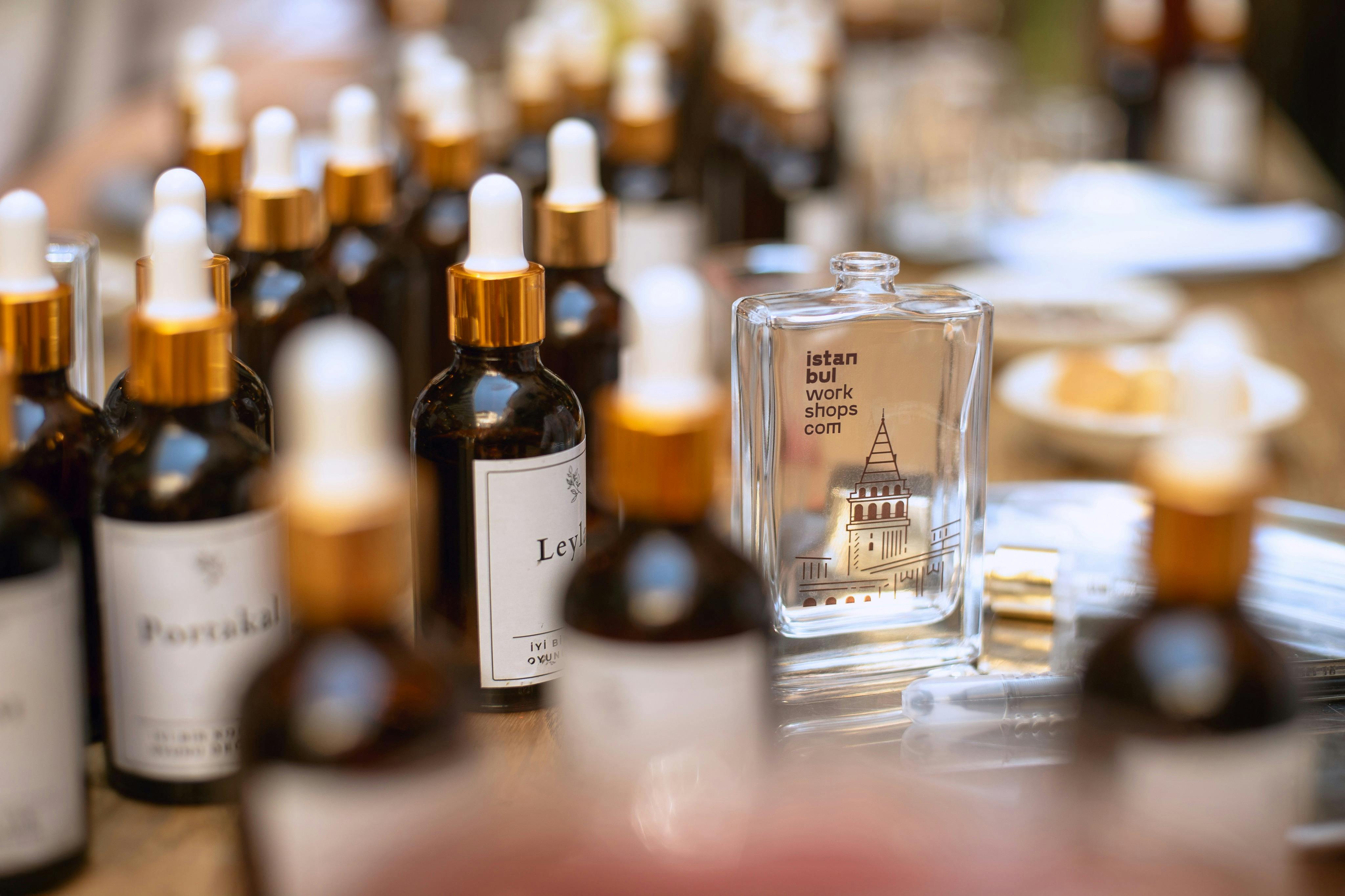 Rows of perfume bottles with one prominently labeled "Istanbul Workshops" on a wooden table.