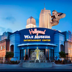 The entrance of the Hollywood Wax Museum Entertainment Center, featuring a statue fountain and King Kong on a skyscraper.