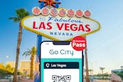 Карта Las Vegas All-Inclusive Pass by Go City на смартфоне с приветственным рекламным щитом Лас-Вегаса на заднем плане