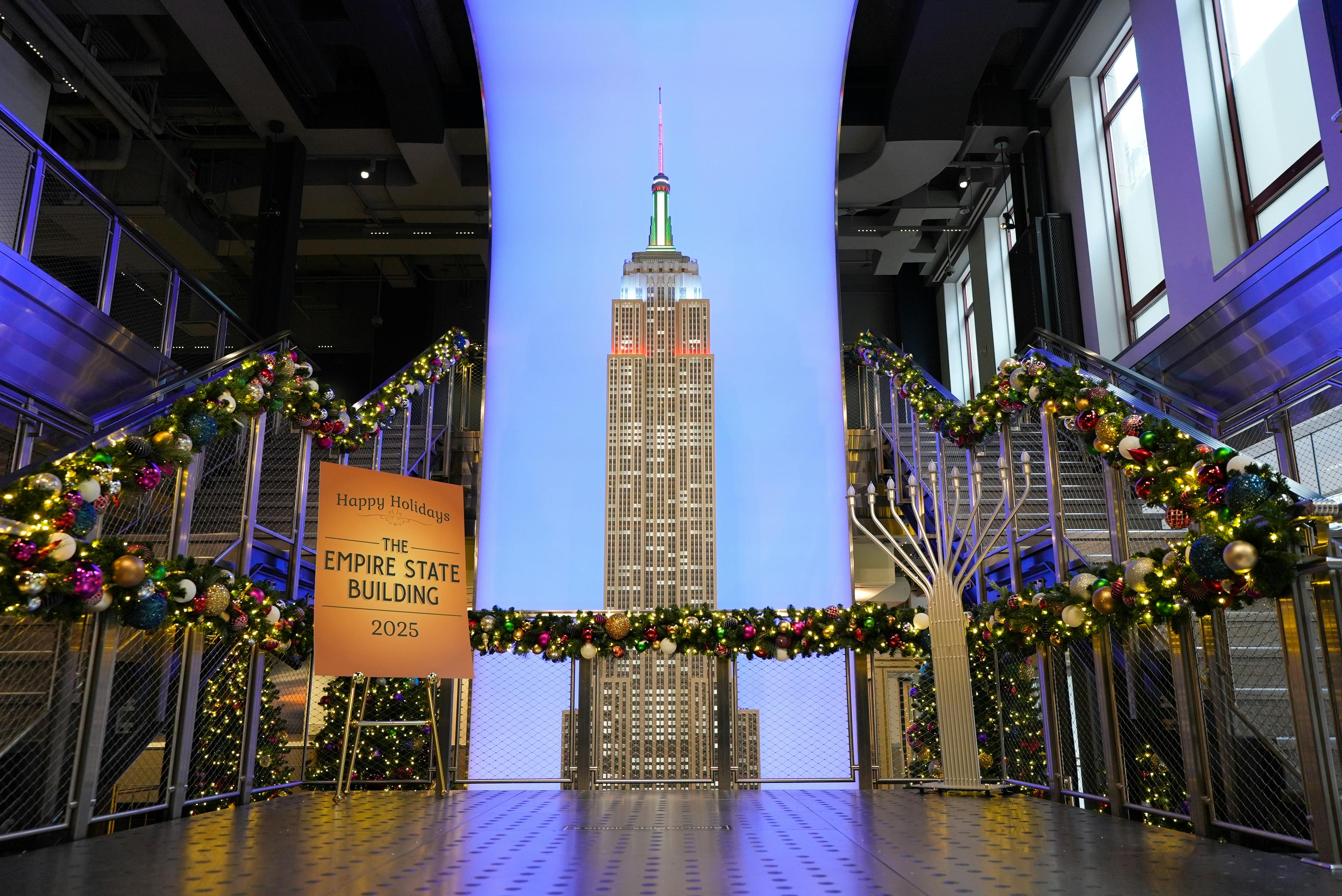 A festive display of the Empire State Building model surrounded by holiday decorations and garlands in an indoor setting.