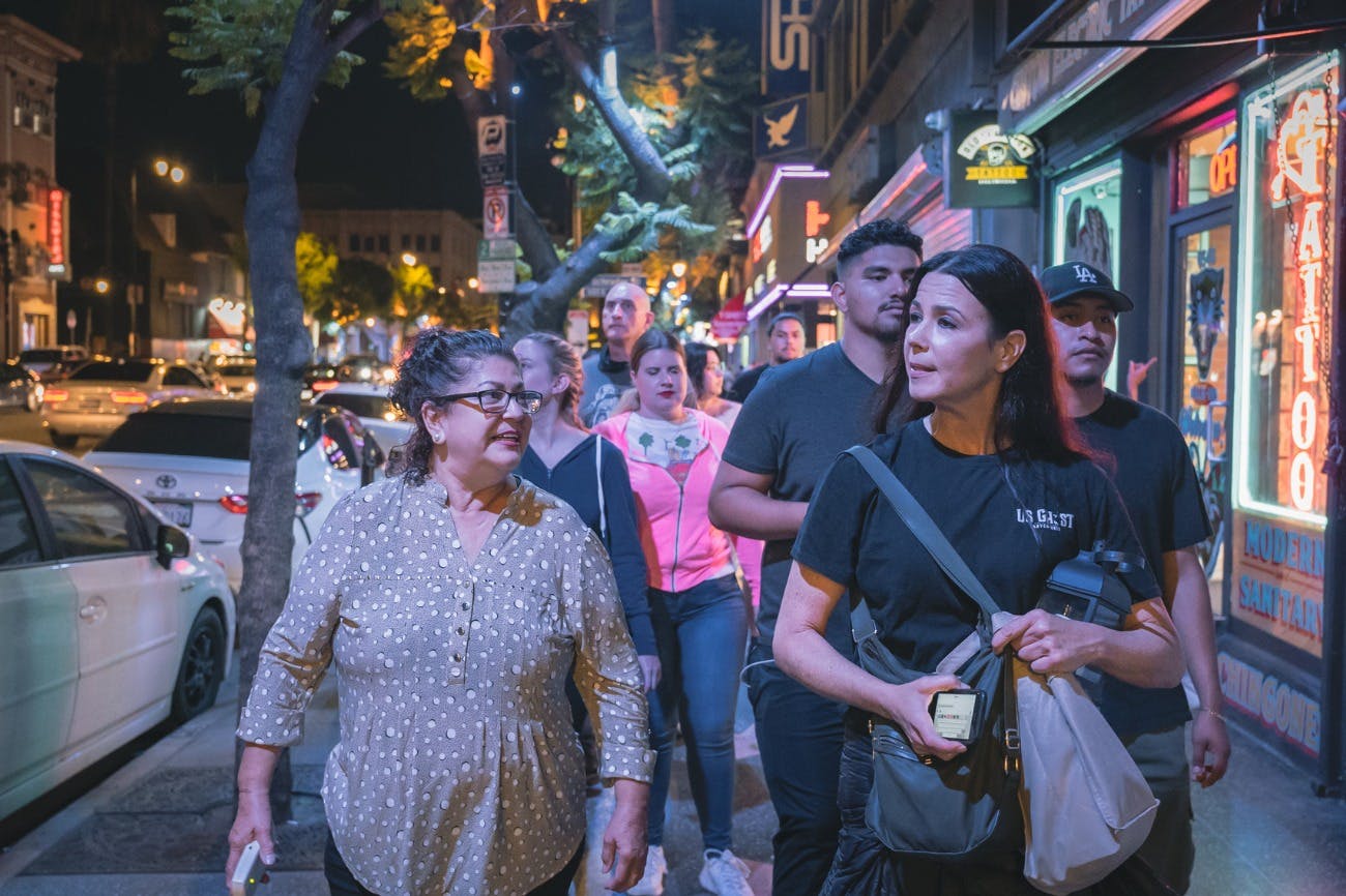 Tour group walking between locations as they listen to their guide tell stories of the city