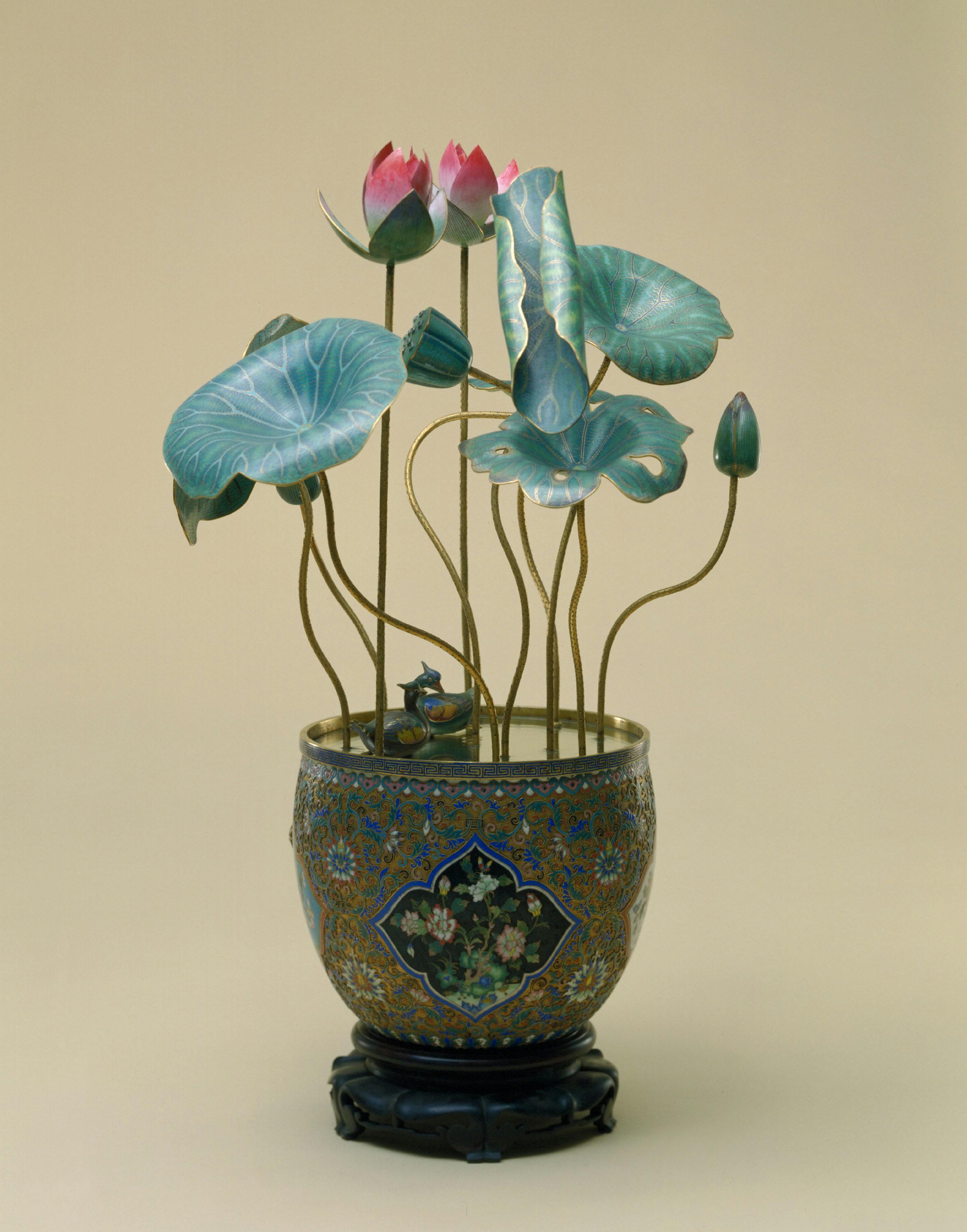 Decorative cloisonné vase with lotus flowers and leaves, featuring intricate patterns, on a neutral background.