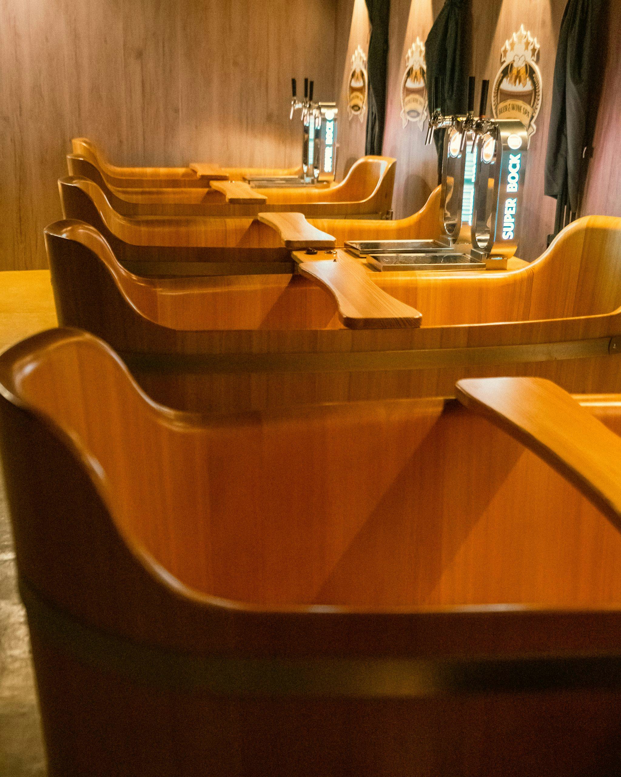 Ξύλινες μπανιέρες στη σειρά με βρύσες μπύρας στο φόντο σε ξύλινο τοίχο.