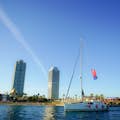 Ein Segelboot segelt an der Küste von Barcelona entlang.