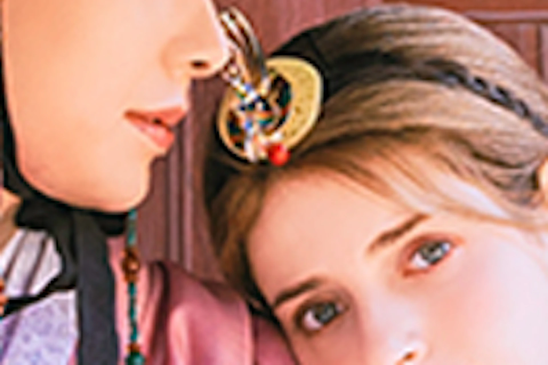 A couple dressed in traditional Korean hanbok sitting together against a wooden building, with a tender and affectionate pose.