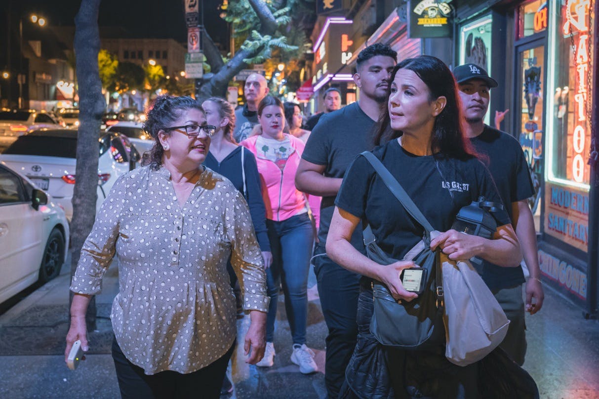 Tour guide leading her group to their next location while telling the history of the city