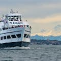 Argosy Cruise boat with Mount Rainier in the background, with people visible on the outer decks. 