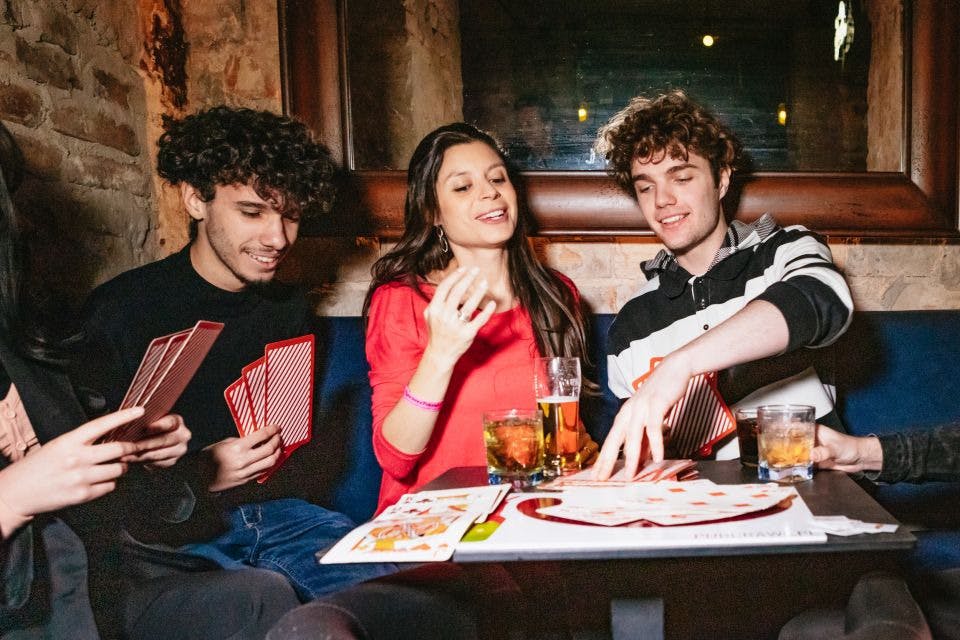 Žena a dva kluci hrají karty