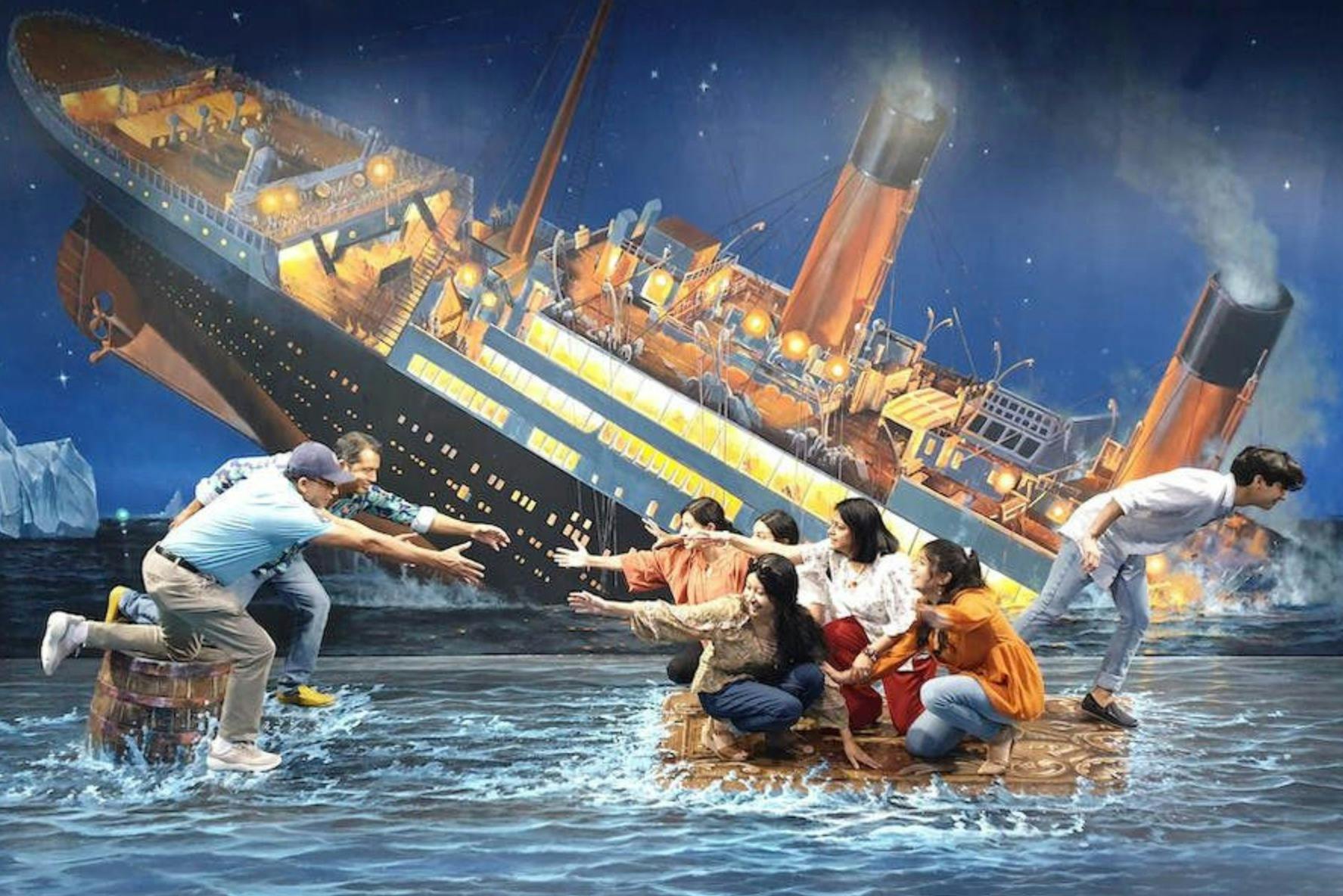 A group of people pose in front of a mural depicting a sinking ship, simulating a dramatic rescue scene with gestures.