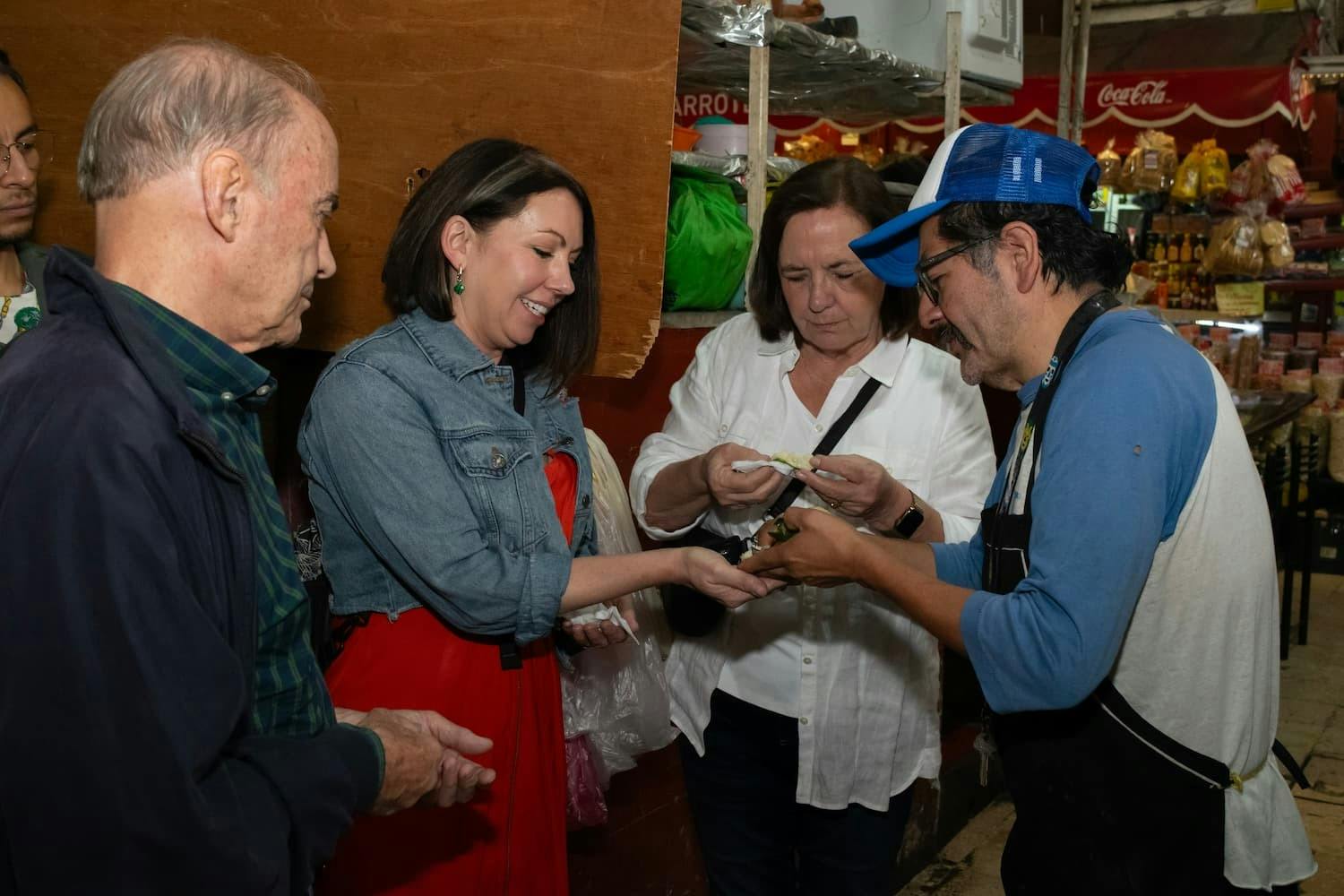 Φιλική αλληλεπίδραση μεταξύ των επισκεπτών και ενός τοπικού πωλητή σε μια μεξικανική αγορά.