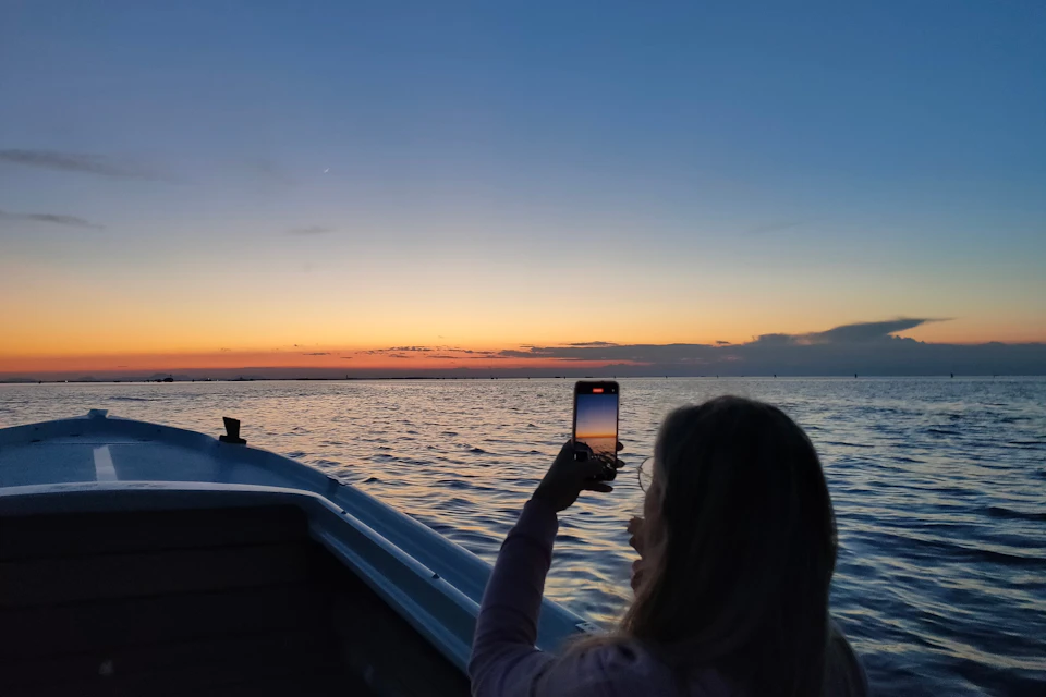Customer taking video during sunset boat tour
