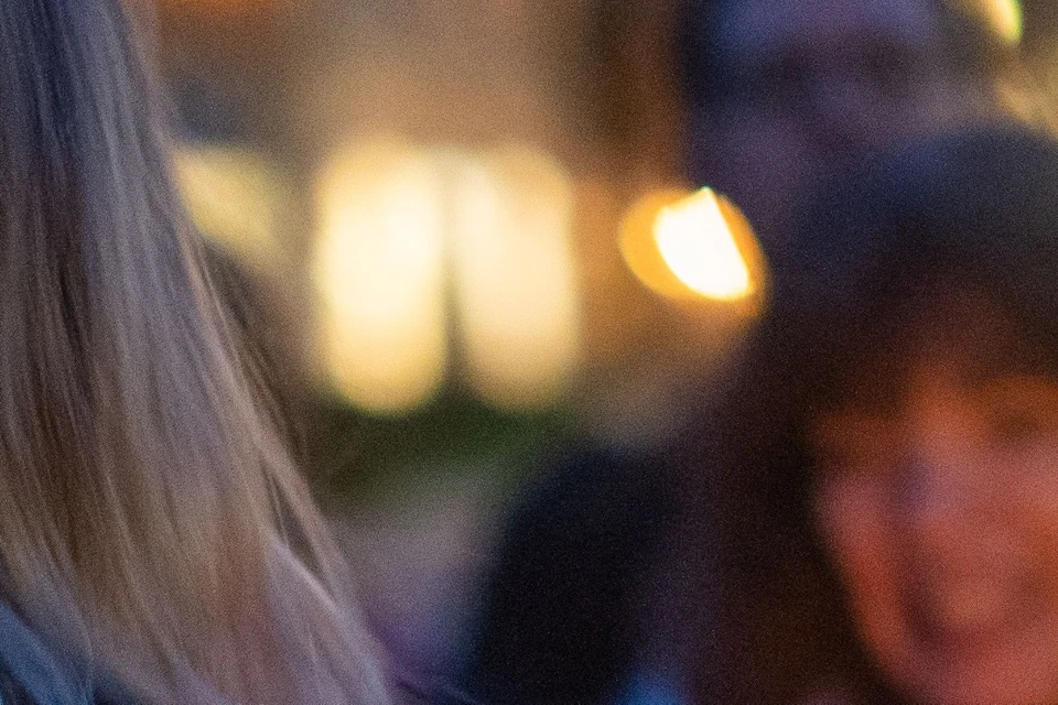Tour guide holding a lantern as guests surround her to listen to ghost stories