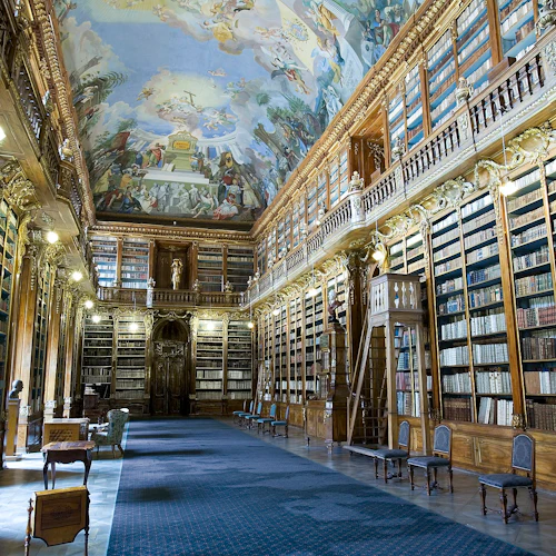 Ett överdådigt bibliotek med höga bokhyllor i trä, utsmyckade dekorationer, ett målat tak och en blå matta.