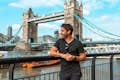 Un touriste se fait prendre en photo devant le Tower Bridge.