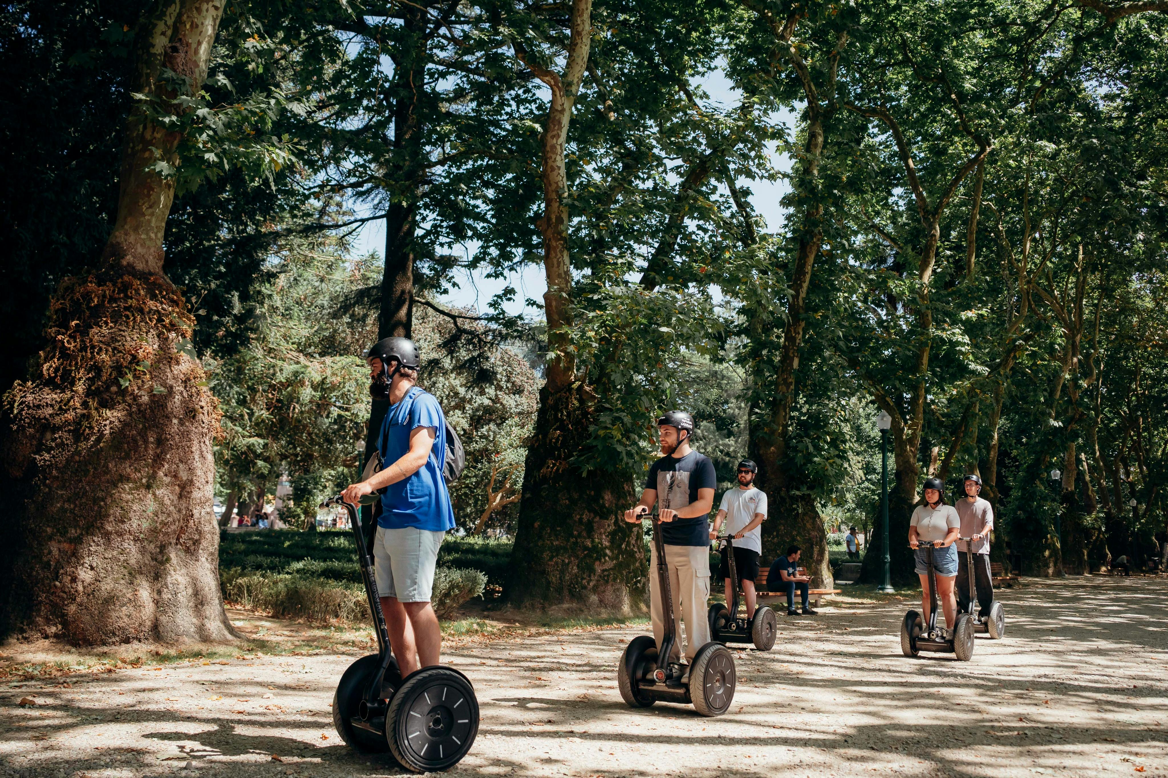 공원의 가로수 길에서 세그웨이를 타는 사람들.