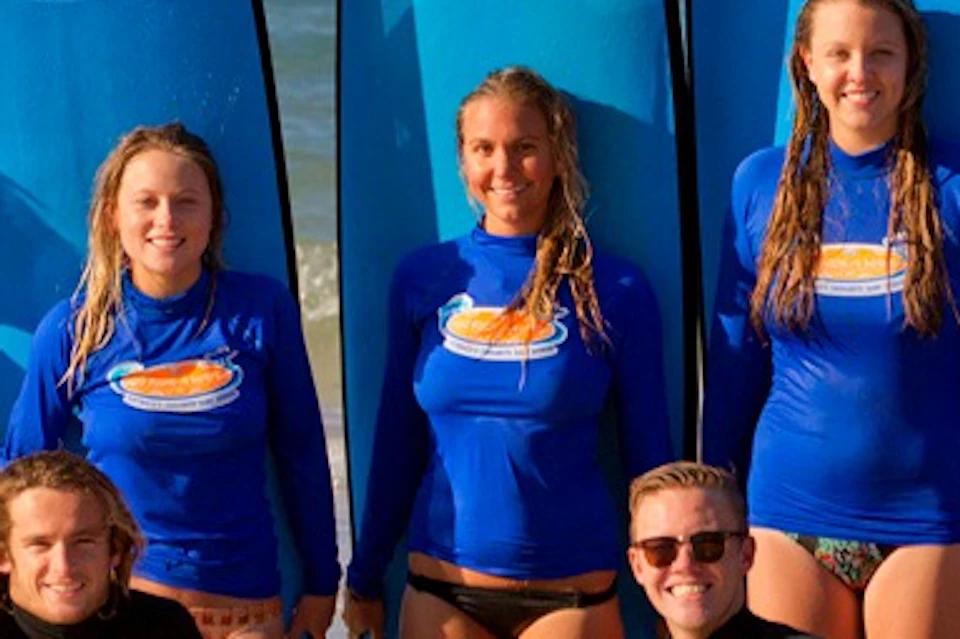 Group photo of successful surfers at the end of the surf lesson.