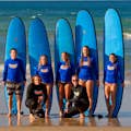 Zdjęcie grupowe udanych surferów na koniec lekcji surfingu.