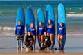 Foto de grupo dos surfistas bem-sucedidos no final da aula de surfe.