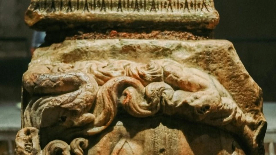 A close-up of an ornate carved stone relief featuring intertwining figures and detailed patterns.