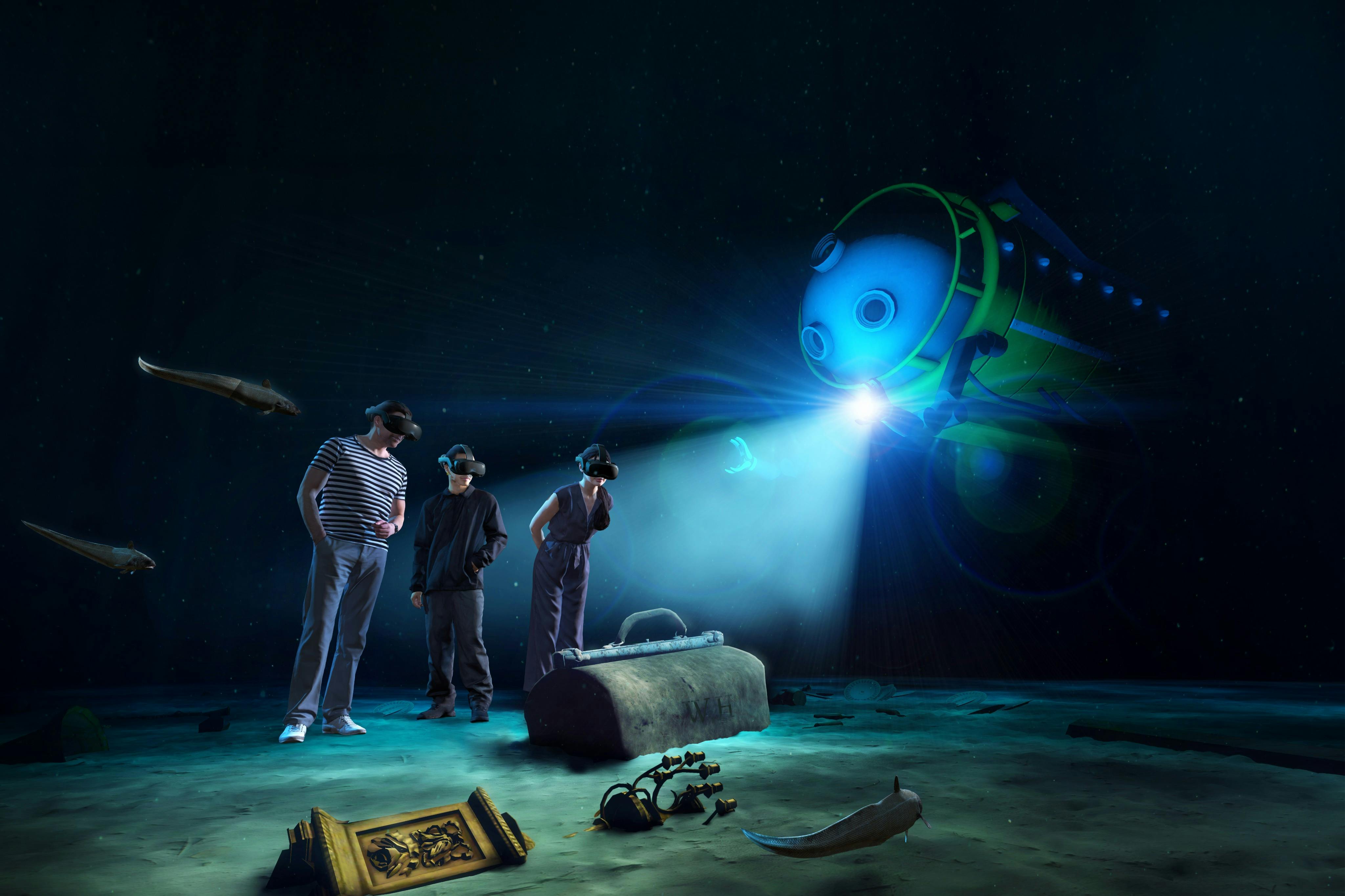 Deux personnes portant des casques de réalité virtuelle se tiennent près de ruines sous-marines, tandis qu'un submersible robotisé équipé d'un projecteur plane à proximité.