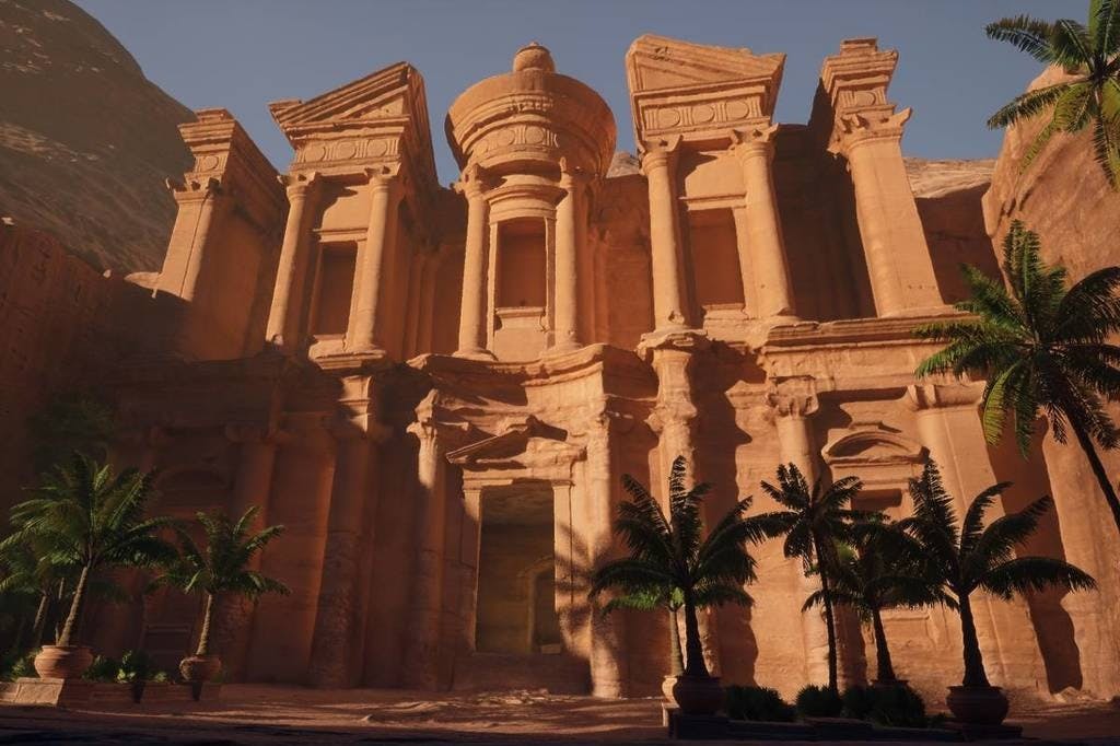 Antico edificio in pietra con colonne e intagli intricati, affiancato da due palme, sotto un cielo limpido.