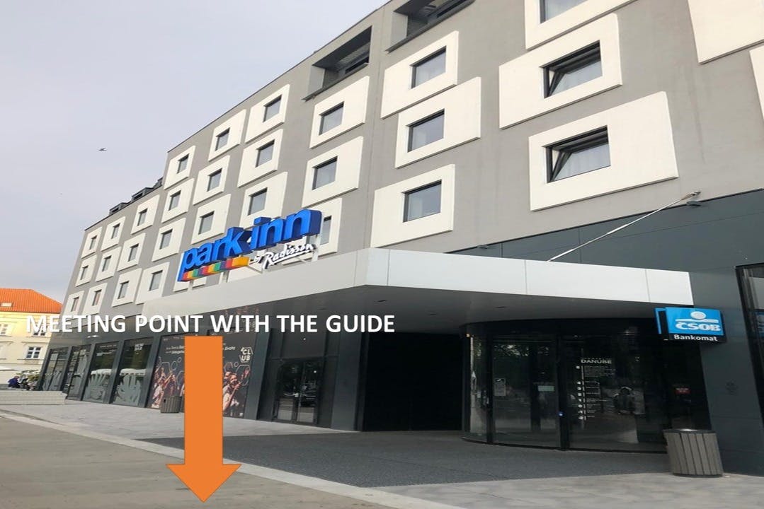 带有「公园客栈」标志的现代酒店外观。 入口处有一个橙色箭头，文字为“POINT WITH THE GUIDE”。