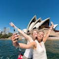 Twee passagiers nemen een selfie voor het Sydney Opera House