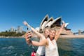 Two passengers taking a selfie in front of the Sydney Opera House