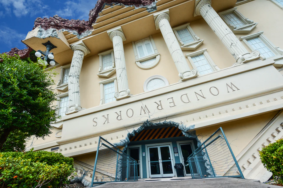 An upside-down building with classical columns and the text 'WonderWorks' above the entrance.