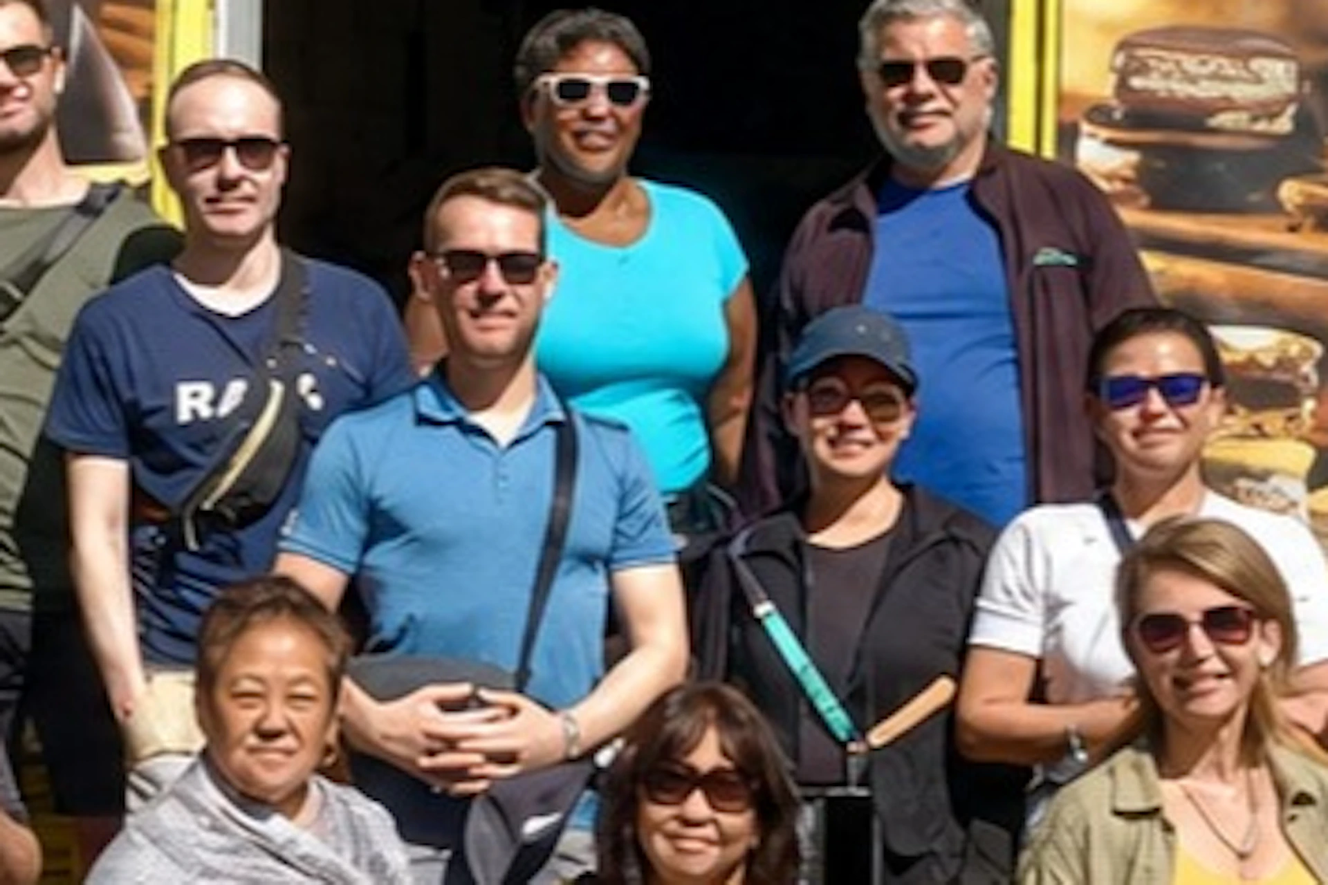 A group of people posing in front of a colorful building labeled "Caminito Tango" on a sunny day.