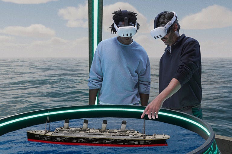 Two people wearing VR headsets stand in front of a 3D digital model of a ship's deck floating on water.