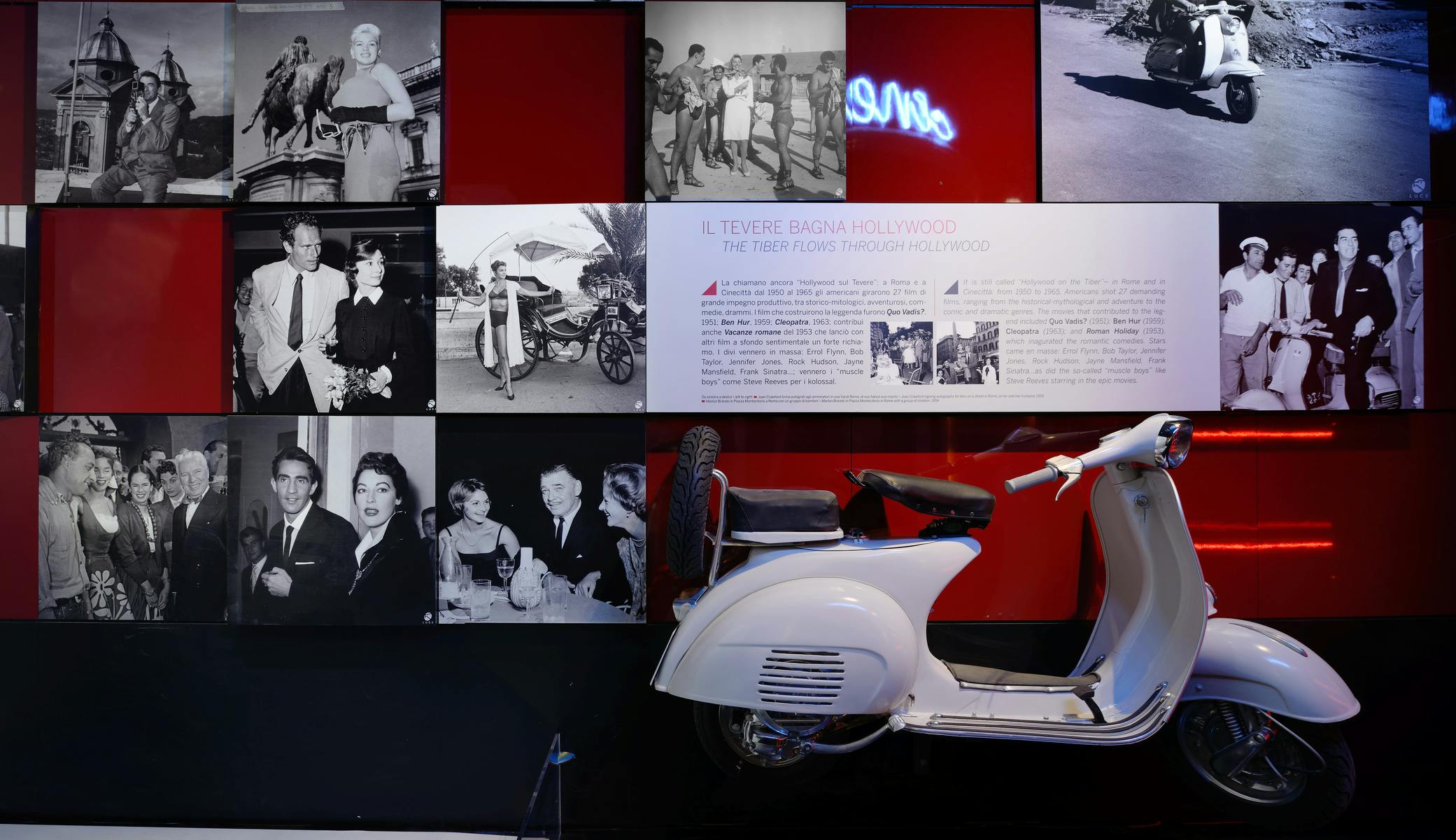 Un collage di foto in bianco e nero su uno sfondo rosso, accanto alla parte posteriore di uno scooter vintage bianco.