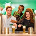 Touristes à l'Expérience Heineken en train de verser une bière.