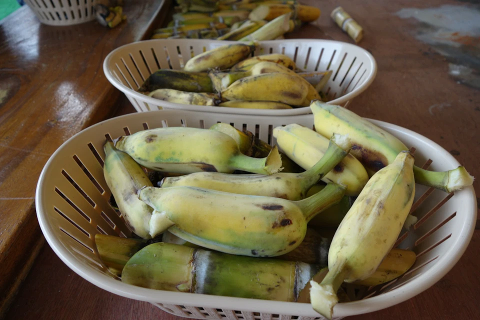 Two baskets filled with peeled bananas placed on a wooden surface.