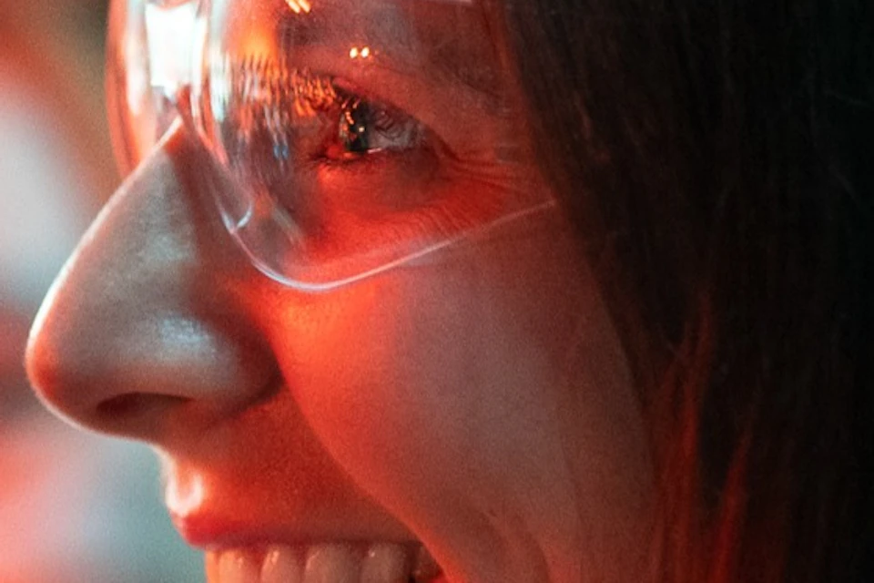 A woman with safety glass watches lava flow at the Lava Show in Iceland.