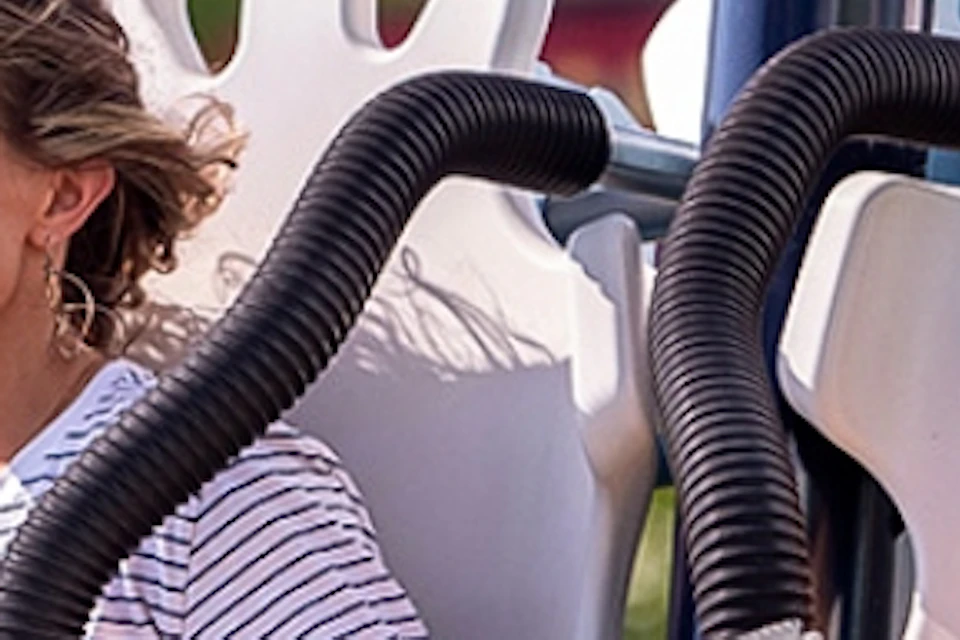 A woman and a child seated on a ride, smiling and enjoying the experience. The child is holding a toy blaster.