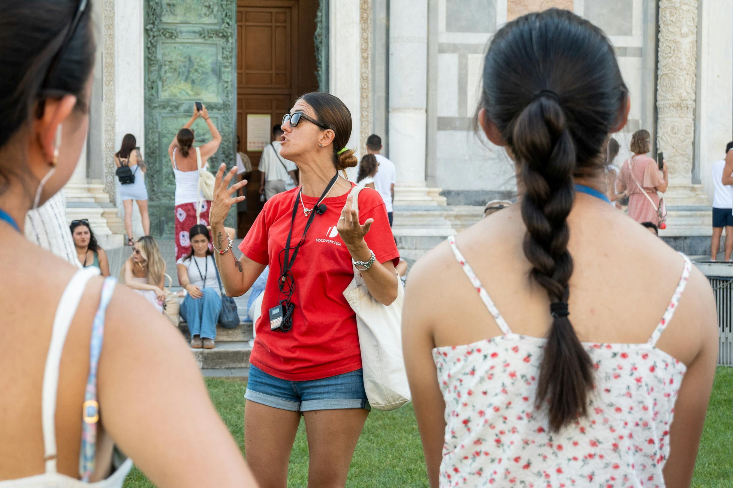 円柱のある華やかな円形の石の内部、中央にあるバプテスマの噴水、そして数人が歩いている空中からの眺め。