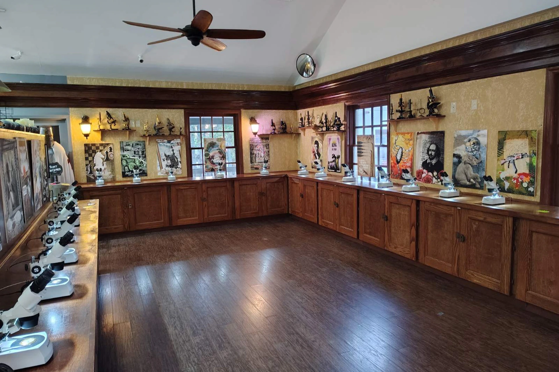 A museum room with polished wooden floors, cabinets displaying artifacts, and historical portraits on the walls.