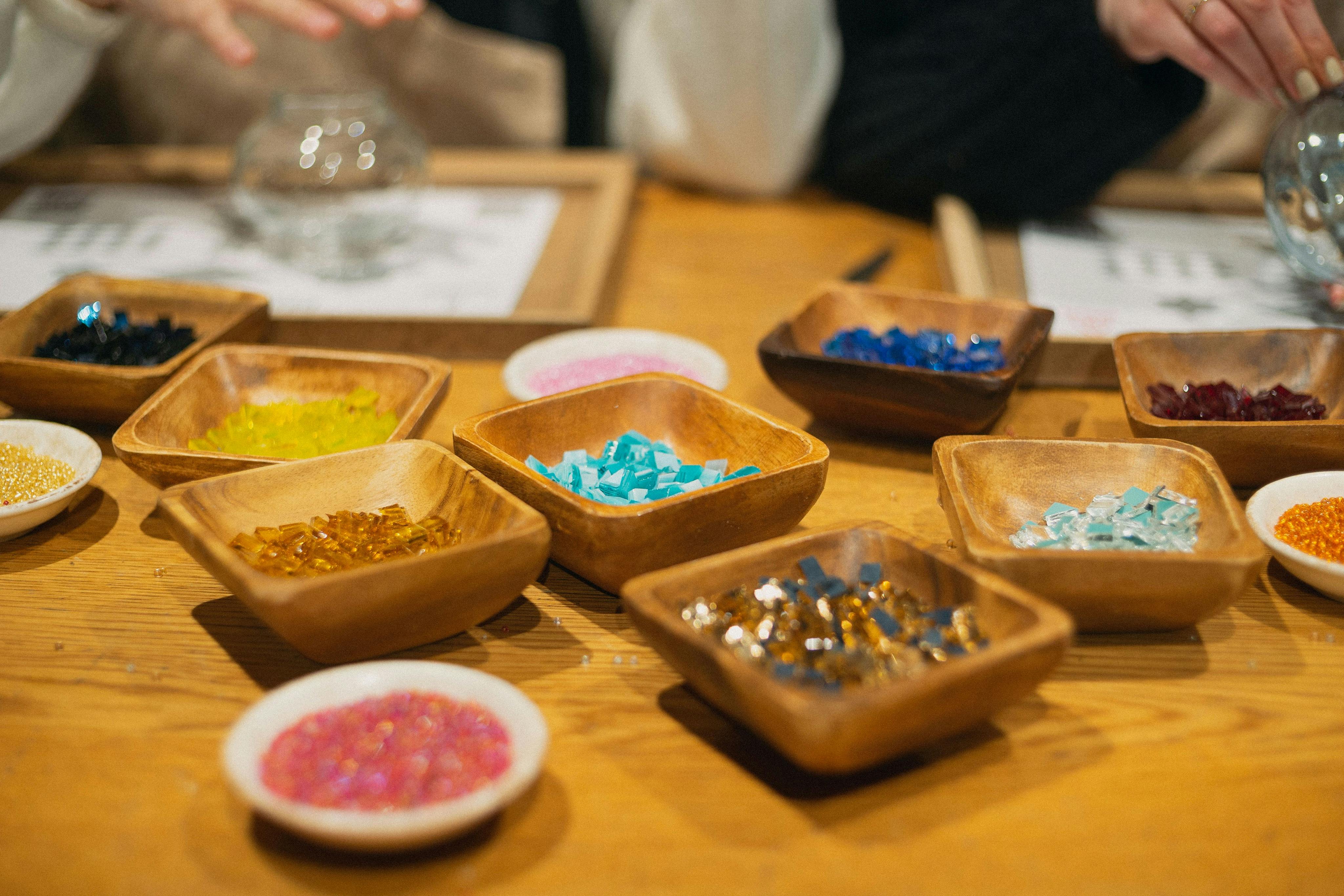 车间桌子上摆满了彩色马赛克石头的木托盘。