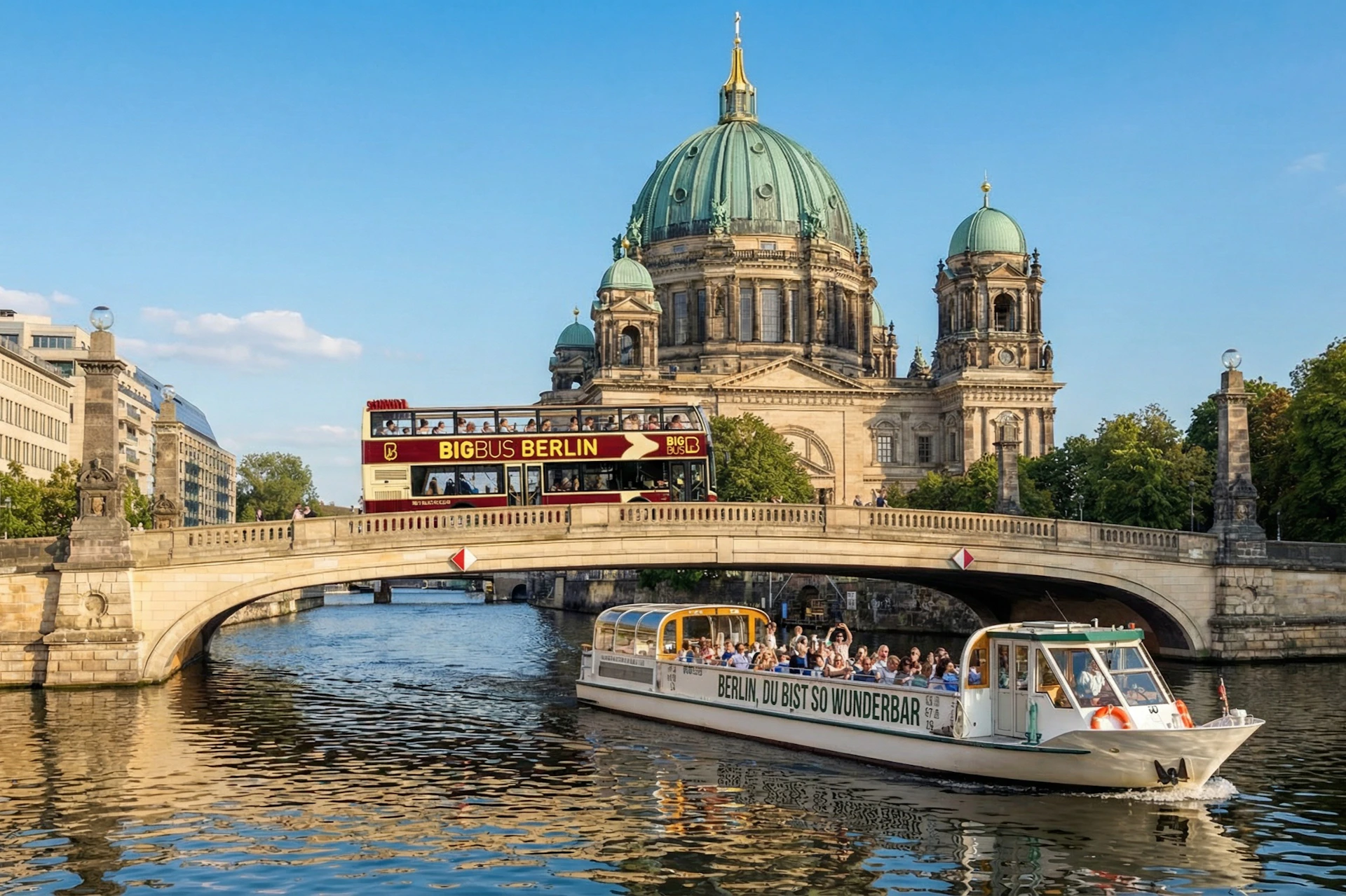 A sightseeing bus crosses a bridge near a riverboat, with the Berlin Cathedral in the background under a clear sky.