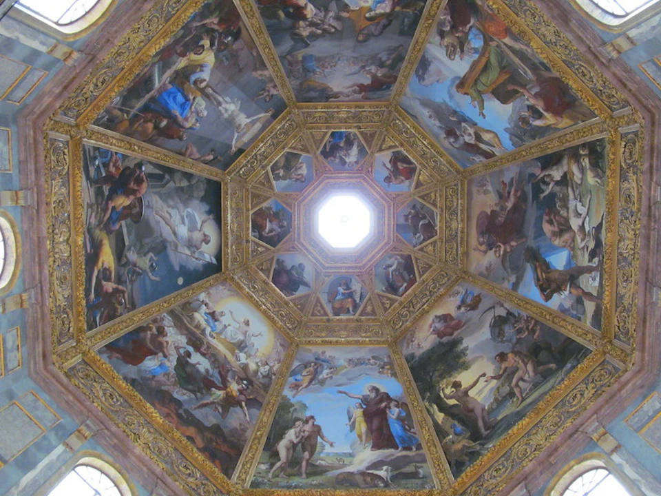 A richly decorated domed ceiling featuring intricate religious and mythological frescoes, surrounding a central skylight.