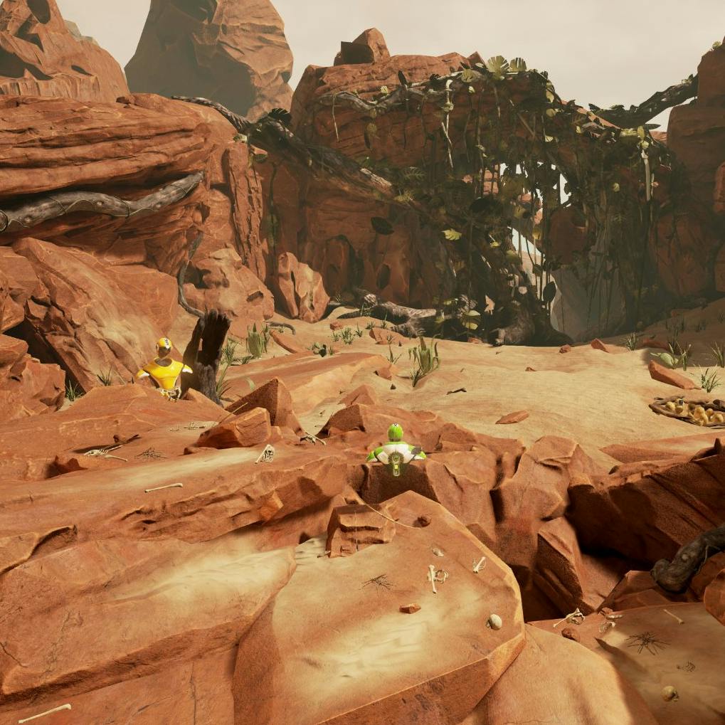 Two small figures in yellow and green suits explore a rocky, desert canyon with large boulders and a bridge-like rock formation.