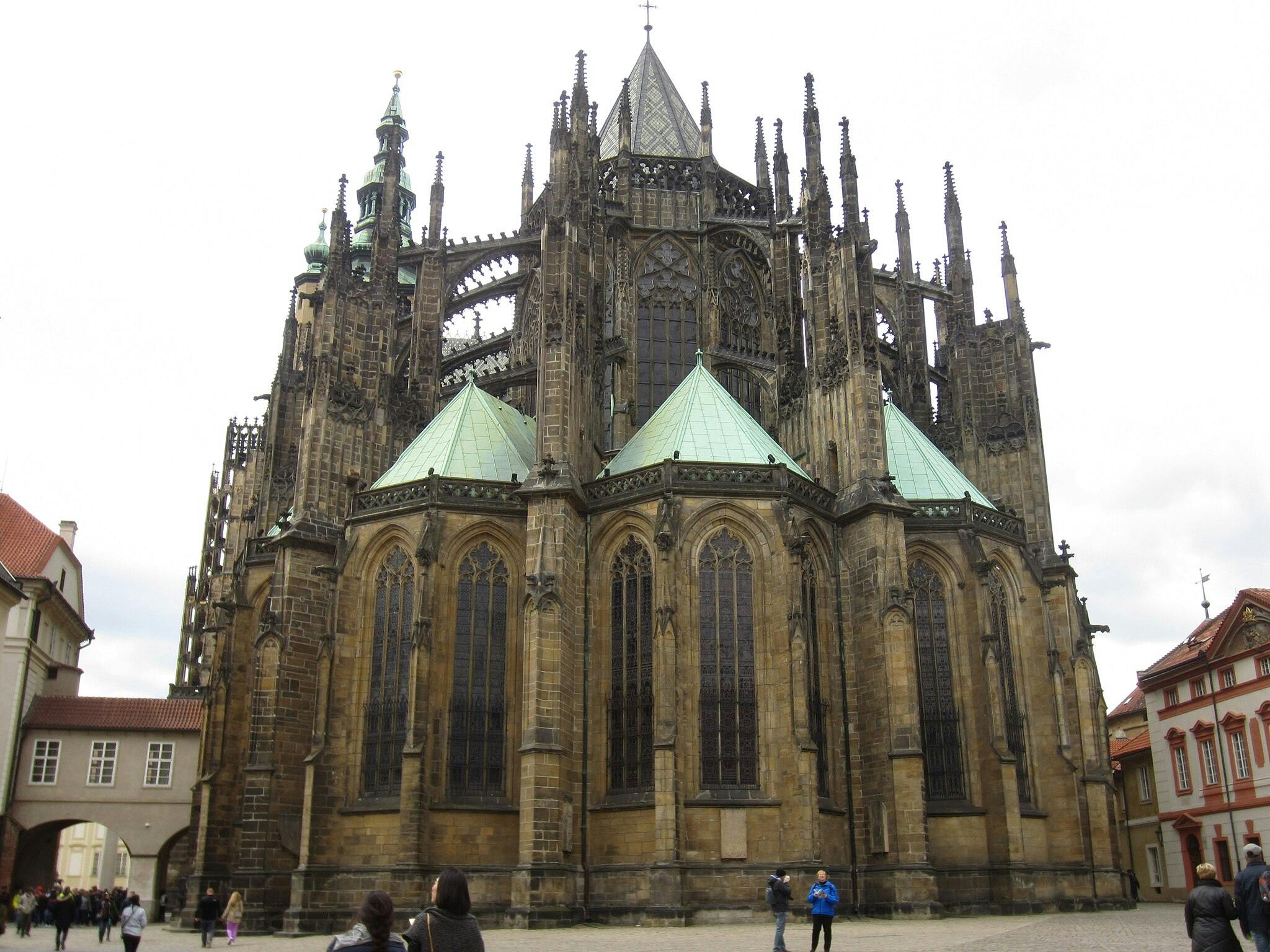 정교한 건축물과 녹색 구리 지붕이 있는 대형 고딕 성당입니다. 사람들이 기지를 돌아다니고 있습니다.