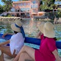 2 Passagiere bewundern eine Villa am Ufer