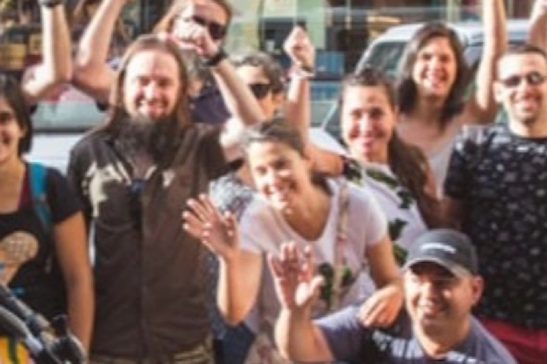 A group of people smiling and posing for a photo with bicycles in front of a storefront.