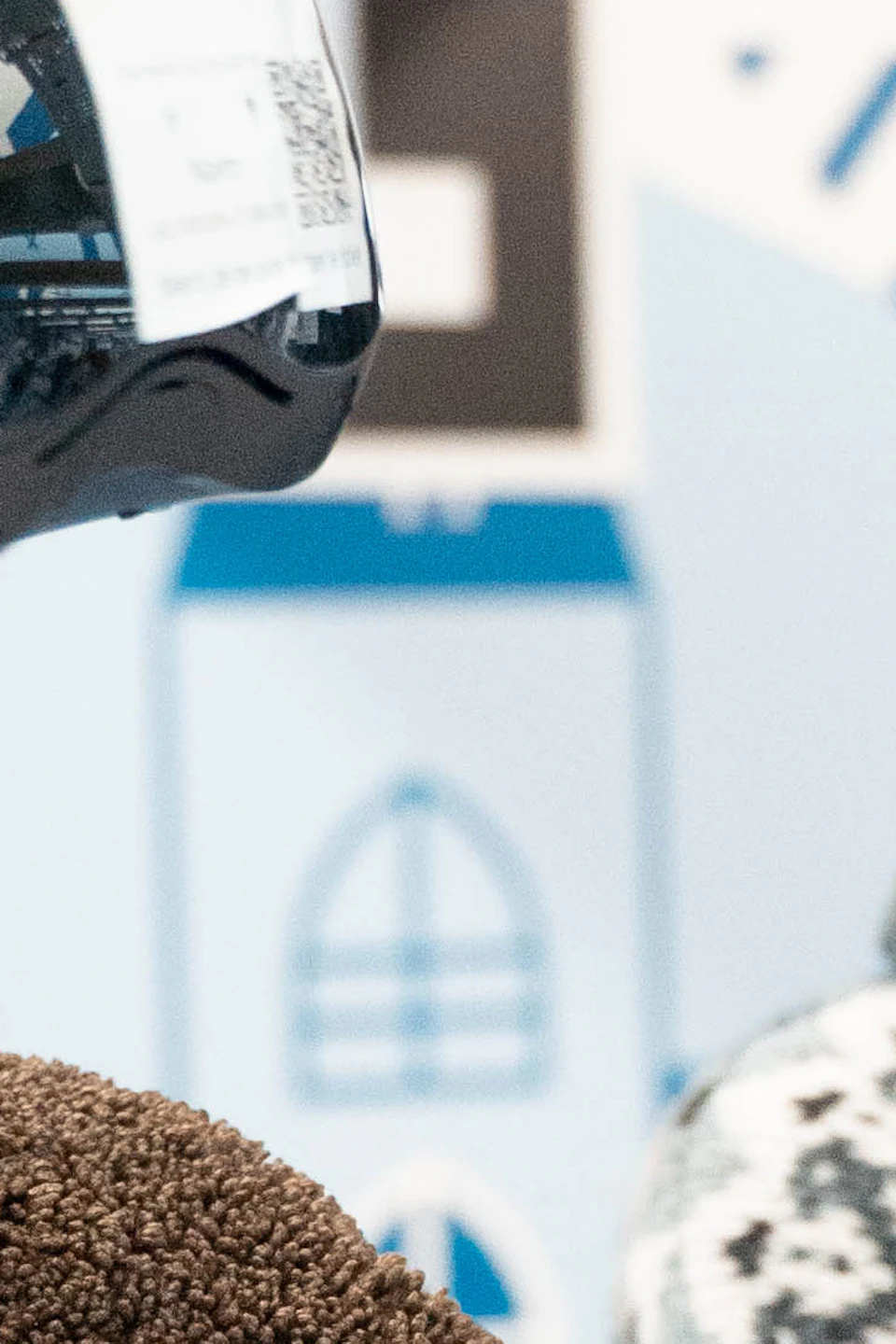 Two women wearing virtual reality headsets, smiling in a futuristic, blue and white setting with abstract patterns.