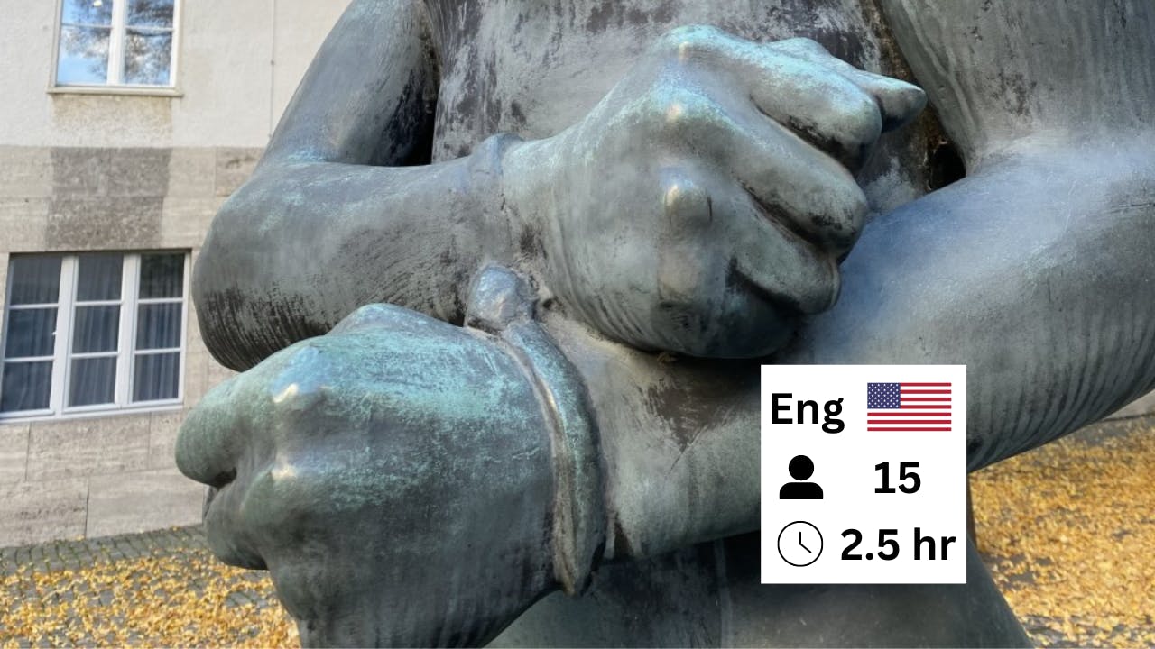 Close-up of a bronze statue showing clenched fists in handcuffs. Part of an icon with the word "Eng," a flag, and numbers is visible.