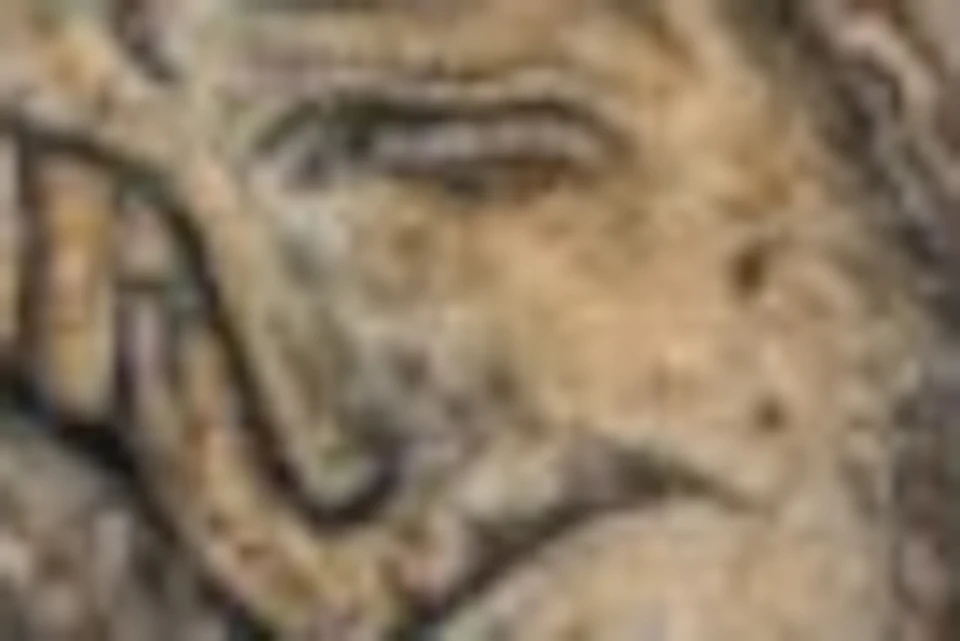 A medieval fresco depicting the crucifixion of Jesus with two mourners and symbolic sun and moon faces above.