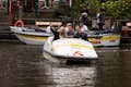 Amigos em um barco a pedal que leva selfies no Canal de Amsterdã
