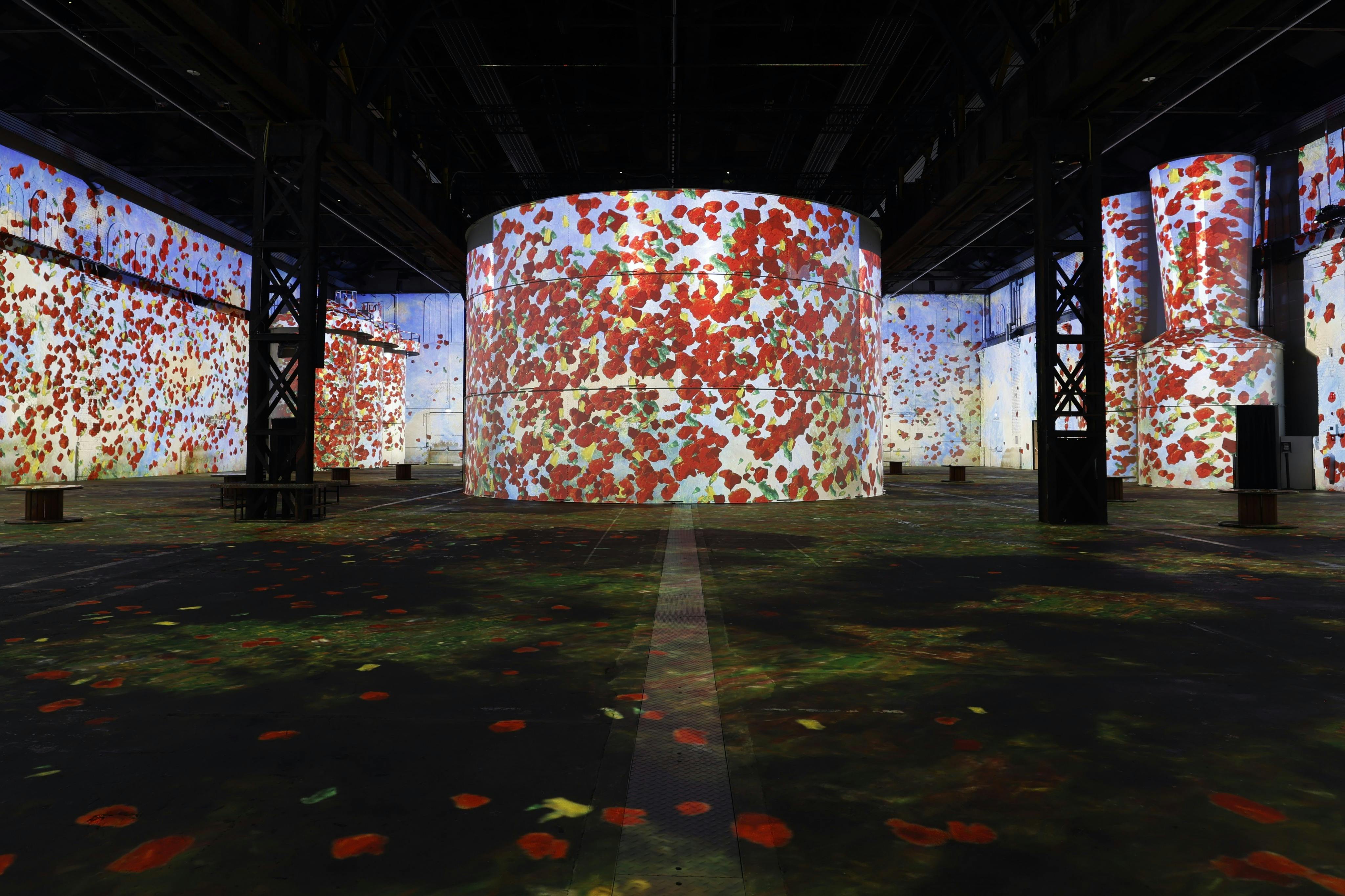 Ένας μεγάλος εσωτερικός χώρος με κυλινδρικούς τοίχους και δάπεδα καλυμμένα με φυτικές προεξοχές, κυρίως κόκκινο και πράσινο.